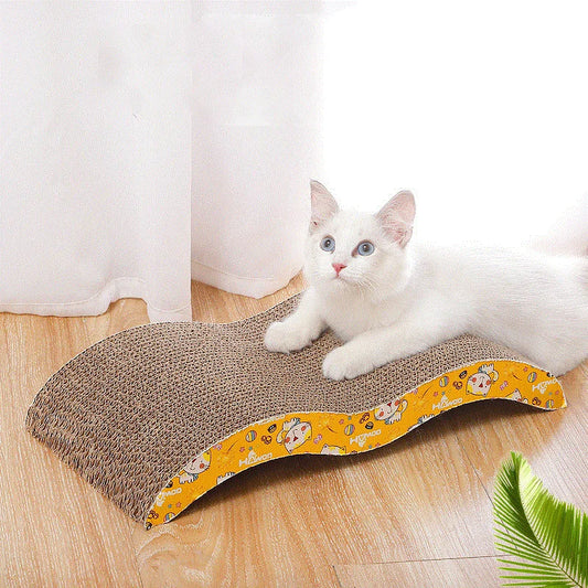 A white cat resting on a corrugated cardboard scratching pad with a yellow patterned border.